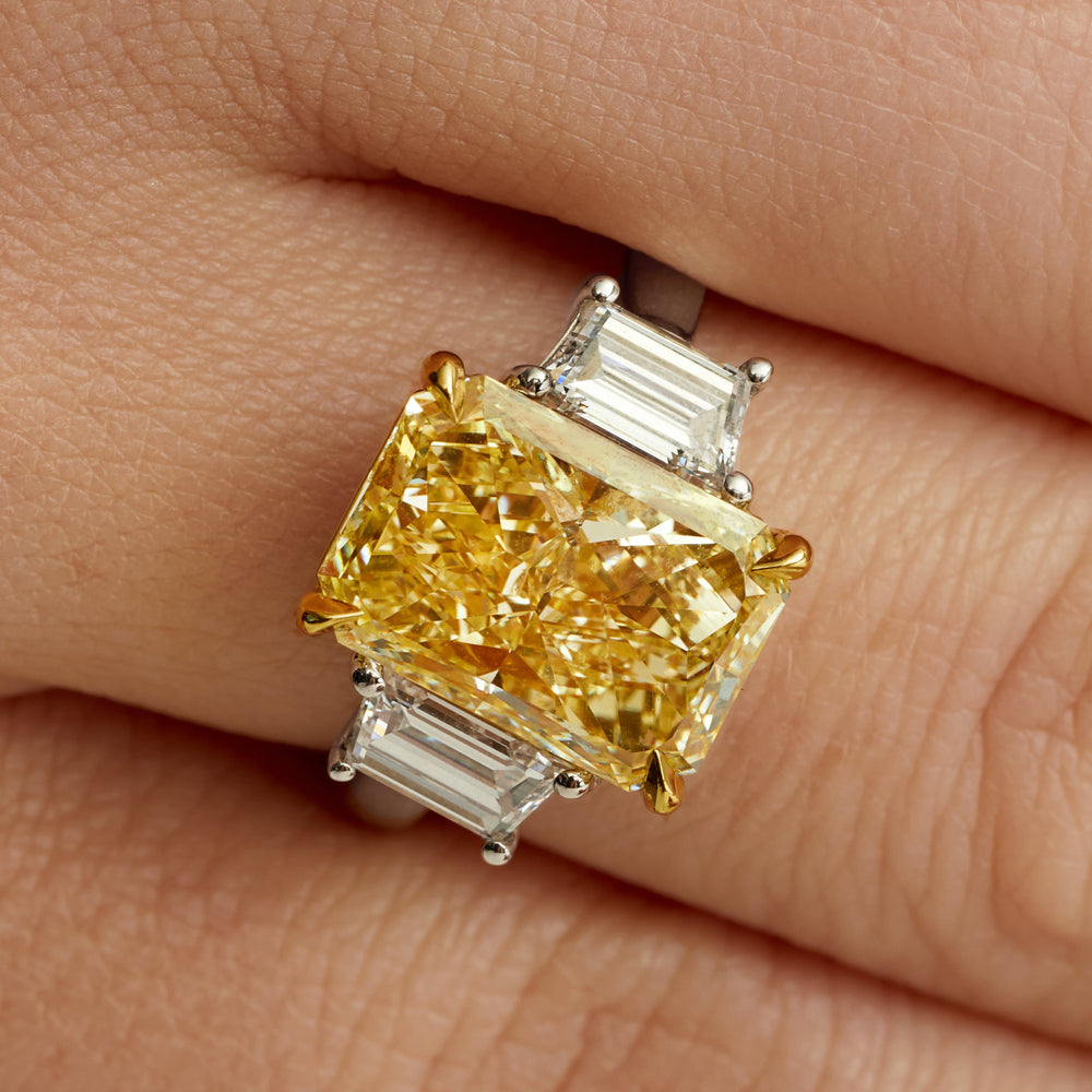 85000-4-carat-radiant-cut-fancy-yellow-diamond-and-trapezoid-diamond-side-stones-three-stone-ring-in-18-karat-yellow-gold-and-platinum-front-view-primary.jpg 4 Carat Radiant Diamond Ring | Fancy Yellow | SI | 18K Gold | A Crown-Worthy Fancy Rarity - Image 1
