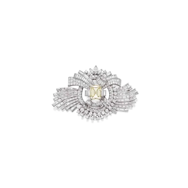 Diamond Brooch| Centering an Emerald-cut Diamond Weighing 14.95 Carats, Within a Decorative Frame of Scrolls and Ribbons